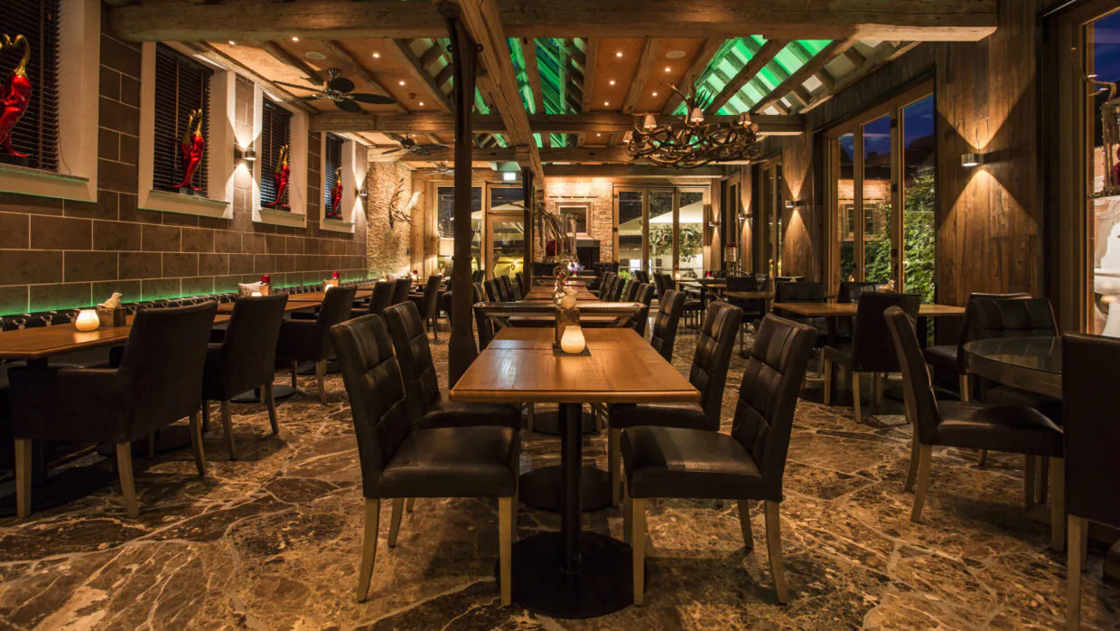 Gemütliches Restaurant mit holzverkleideter Einrichtung und Beleuchtung.