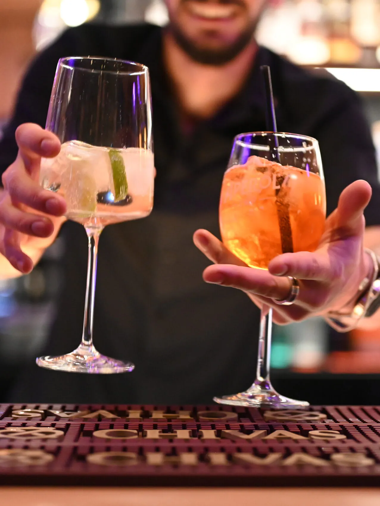 Barkeeper serviert bunte Cocktails in einer Bar