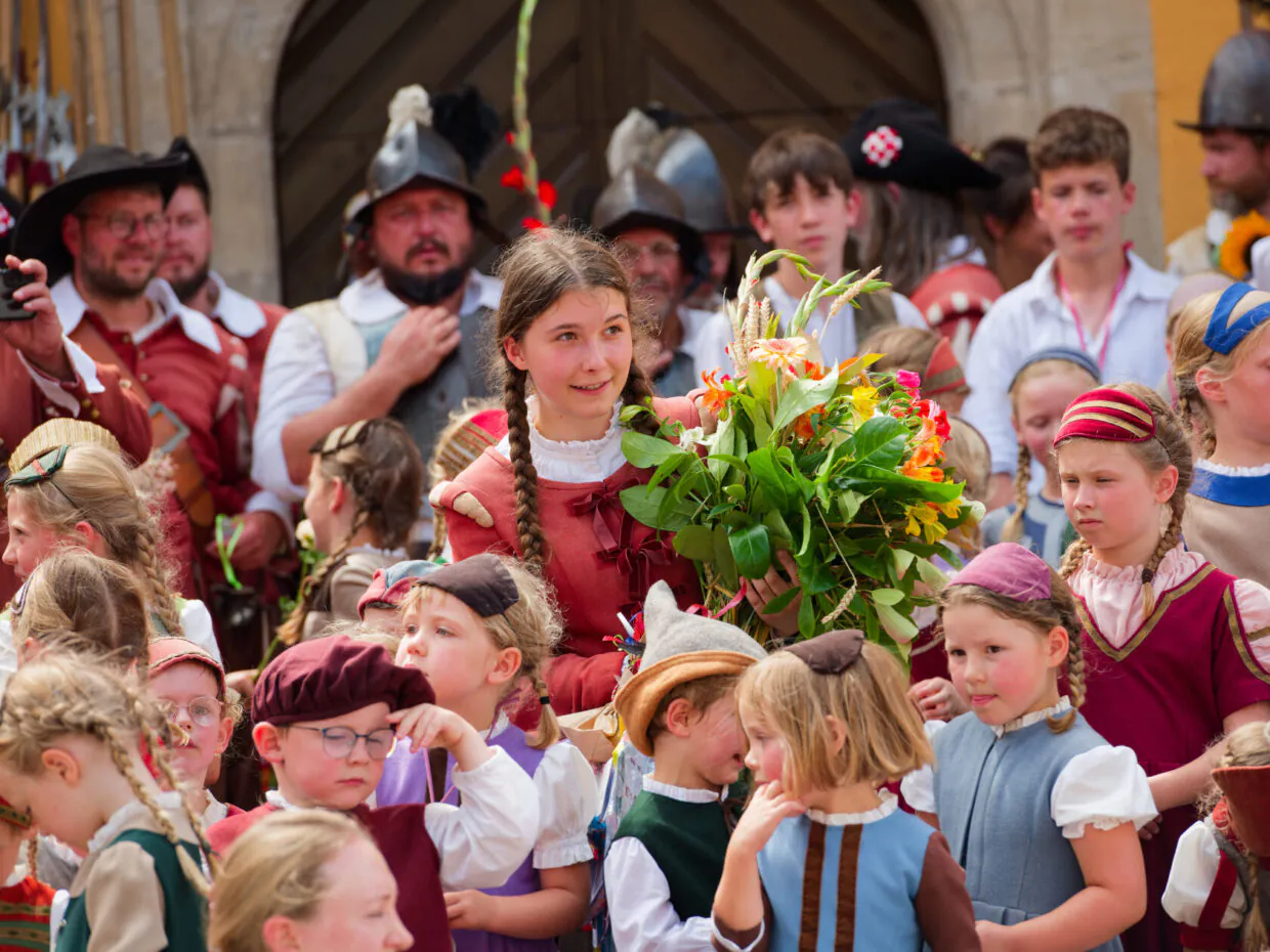 Kundgebung in traditioneller Kleidung mit Blumenstrauß