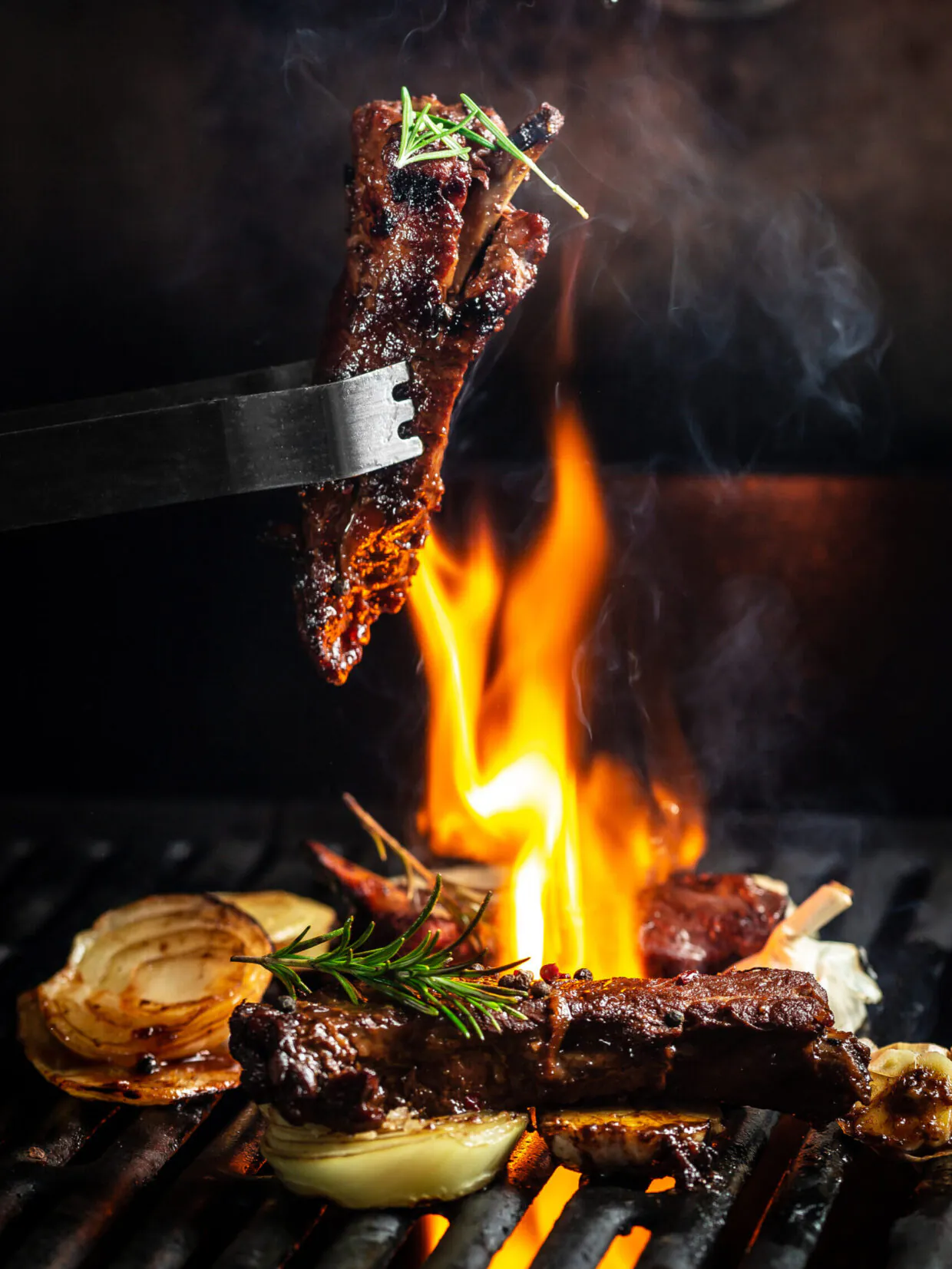 Gegrillte Rippchen mit frischen Kräutern auf Flamme.