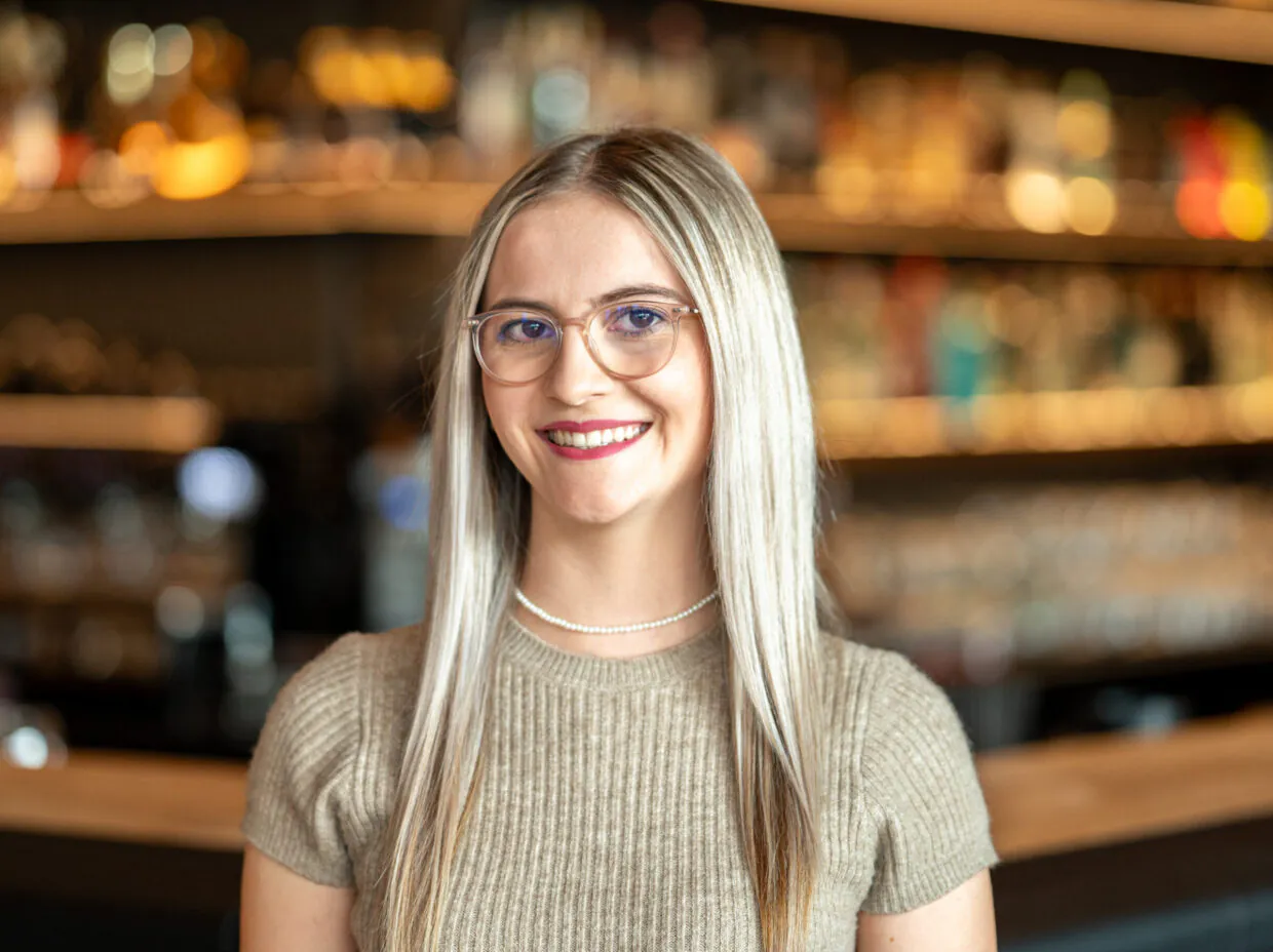 Frau mit Brille lächelt in einem Café