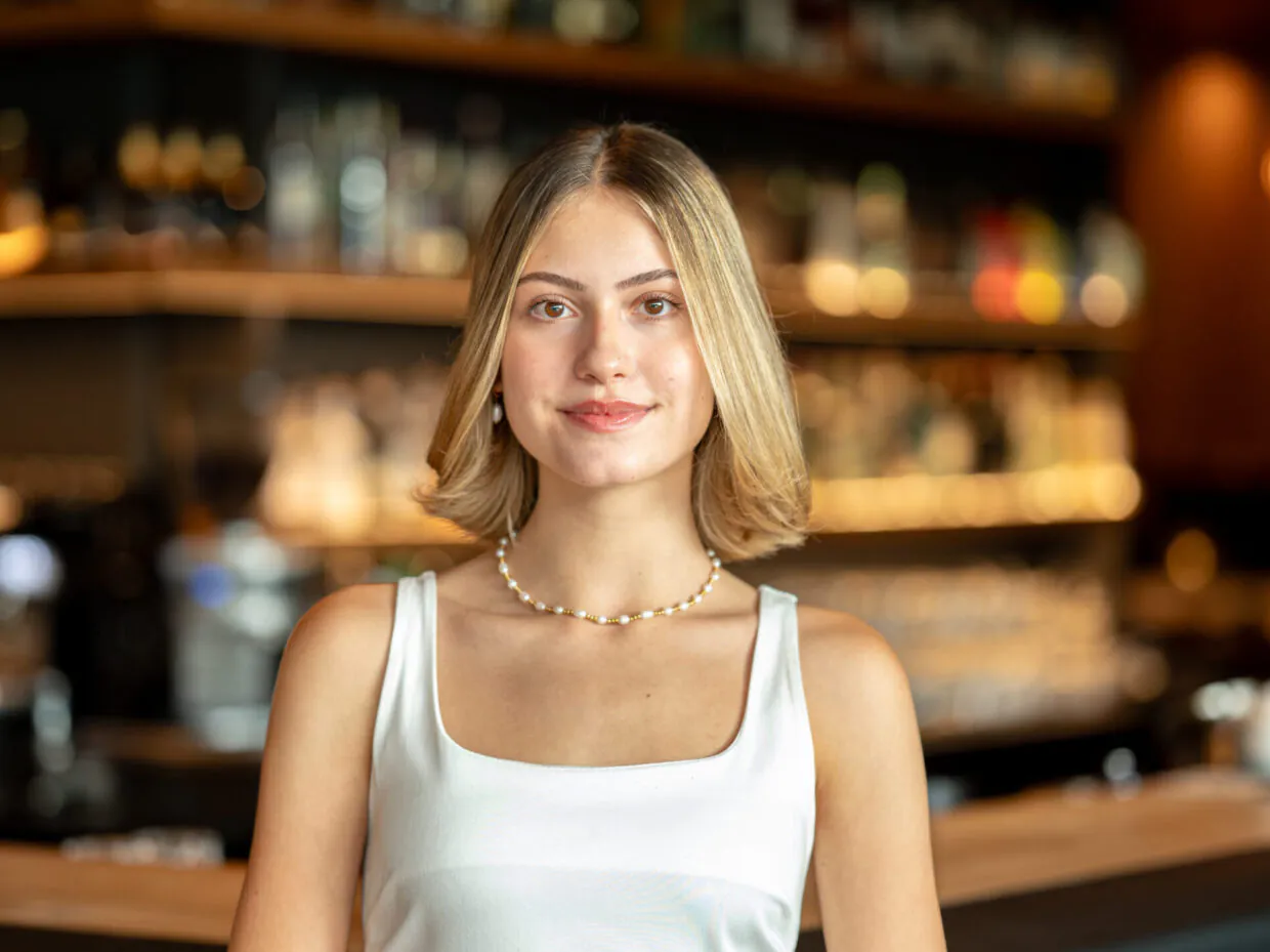 Frau lächelt in moderner Bar-Umgebung