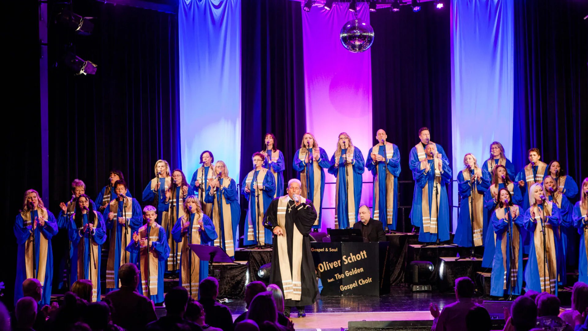 Gospelchor auf Bühne mit buntem Licht