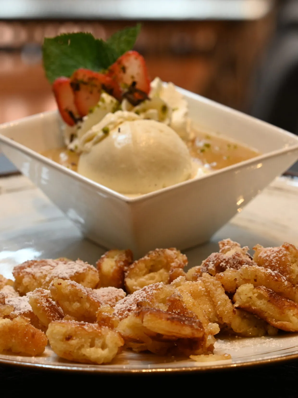 Kaiserschmarrn mit Eis, Sahne und Erdbeeren serviert.