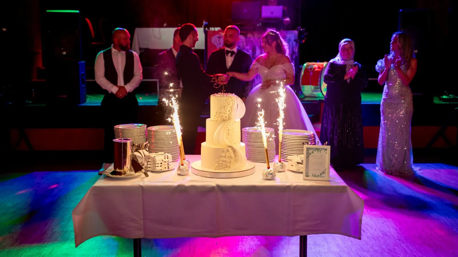 Hochzeitspaar mit Hochzeitstorte und Gästen