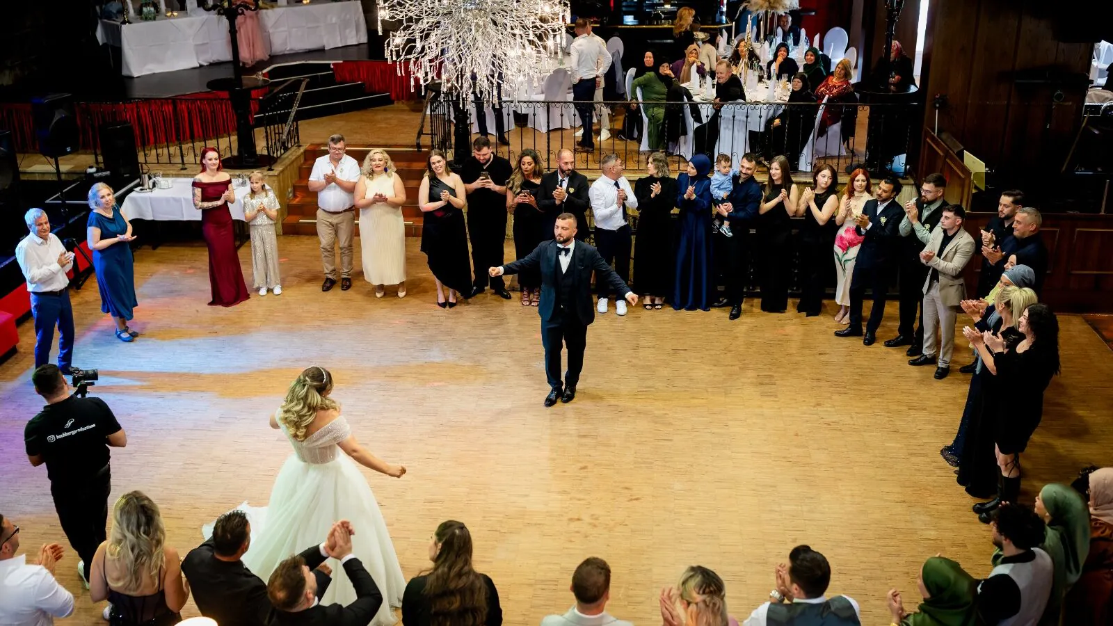 Tanzpaar von Gästen umringt auf Hochzeit